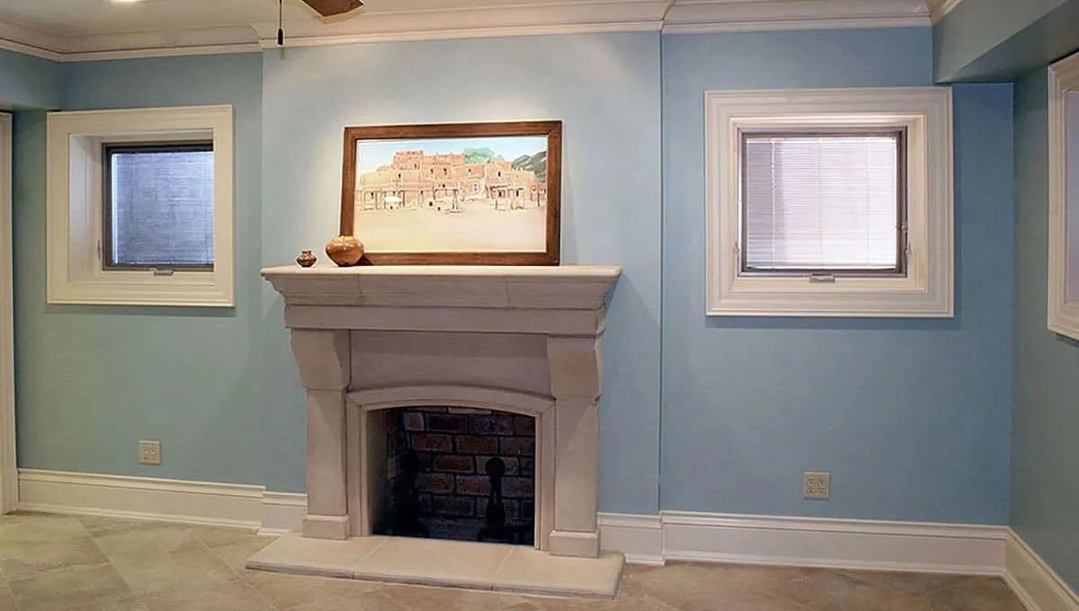 A cast stone fireplace surround with painted moldings