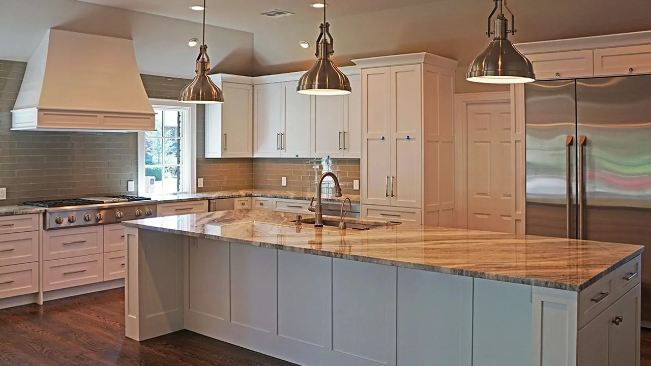 A long kitchen island with copper pendants overhead