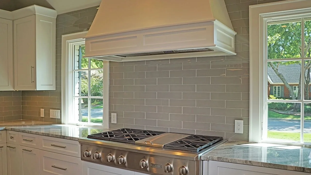A custom wood range hood above a cooktop