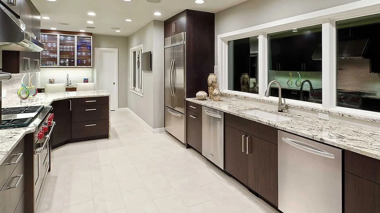 A remodeled kitchen with dark cabinetry, stone counters and a pass-through window